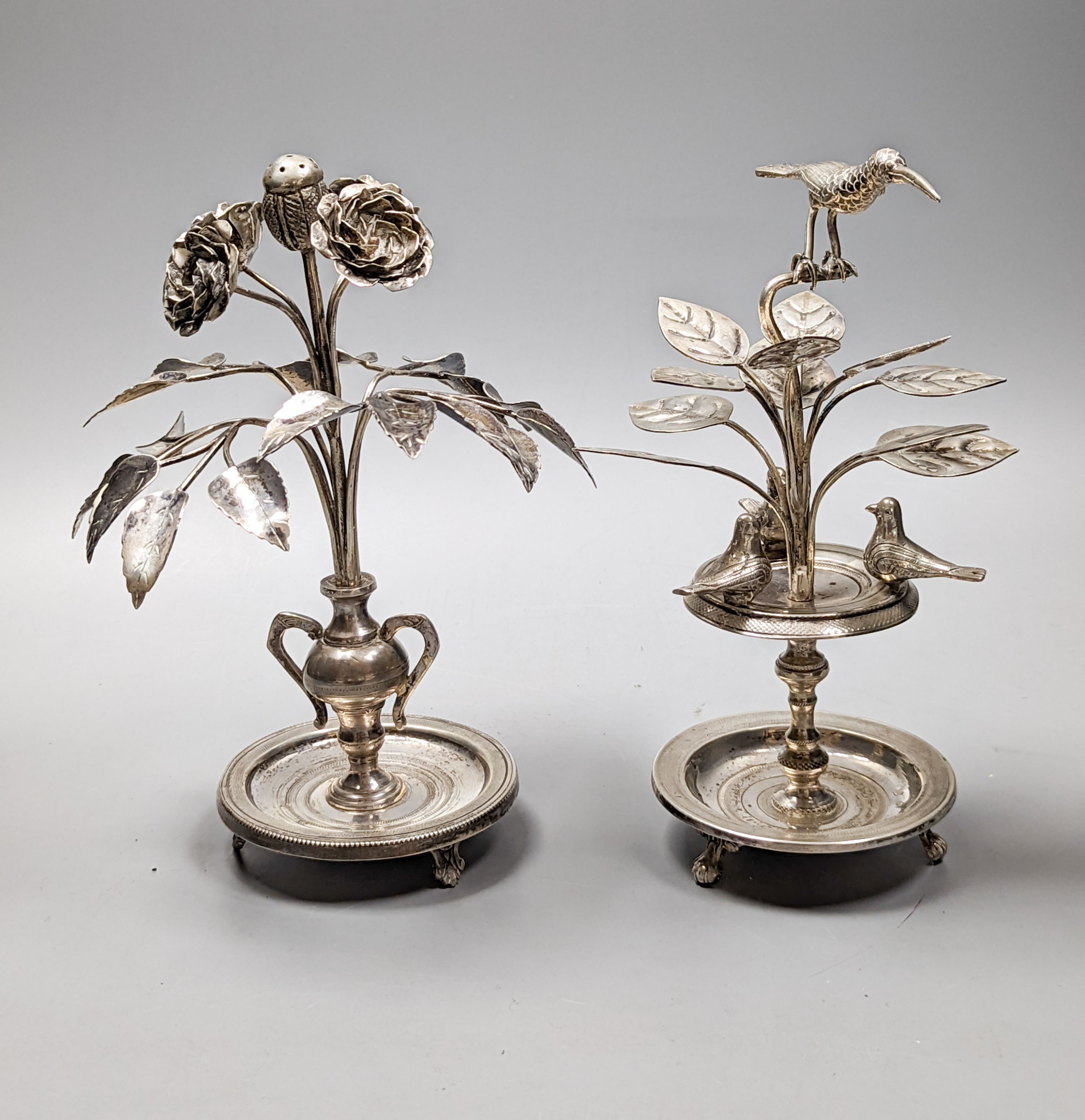 Tw South American? white metal toothpick holders?, modelled as a floral displays with circular bases, one with birds